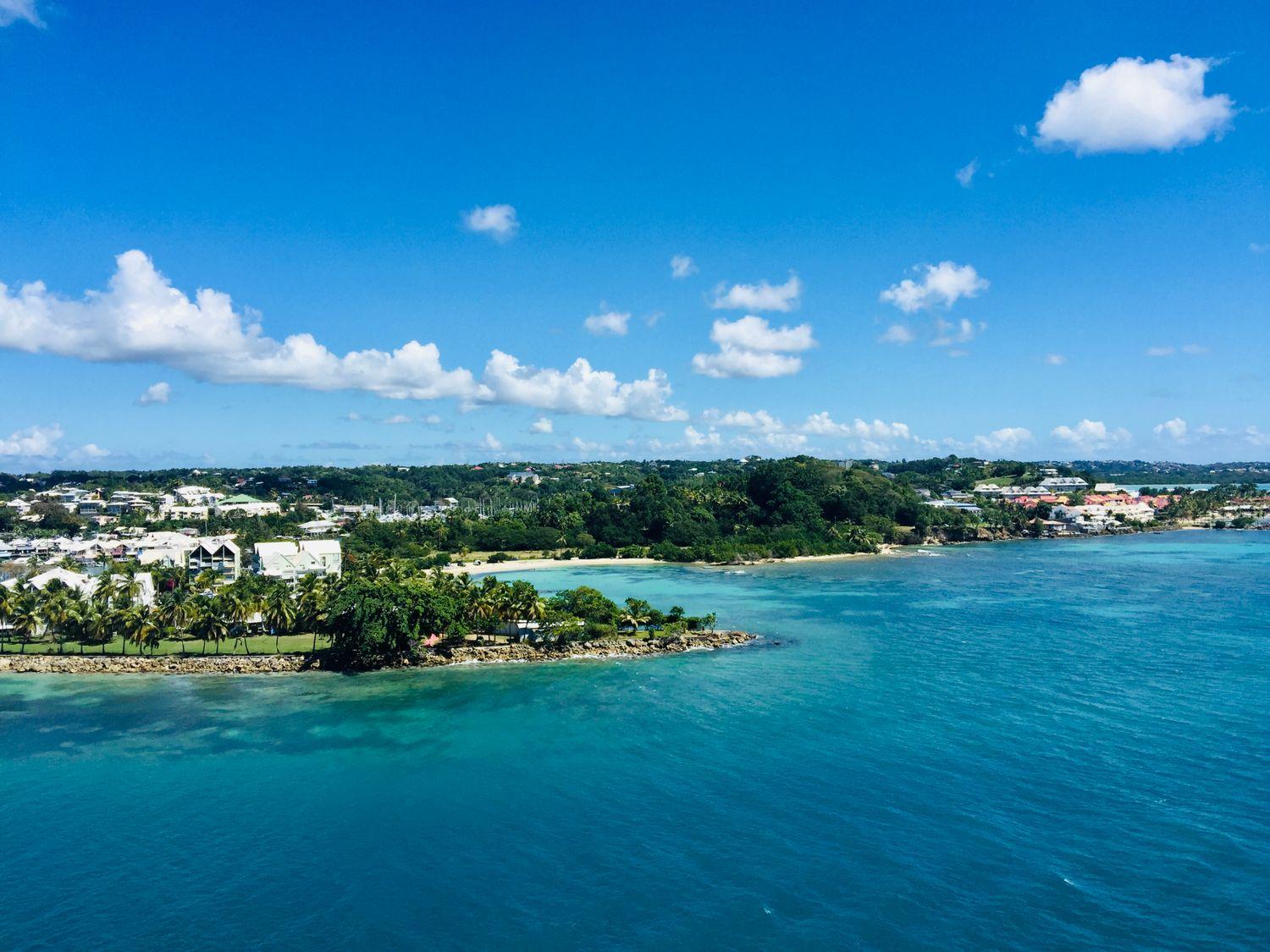 Landzungen an der Küste der Karibik mit Palmen, weißen Hausern in himmlisch blauem Meer
